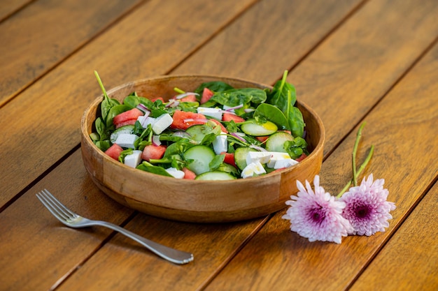 Insalata verde sana in una ciotola con olio di pomodoro e spinaci e cetriolo