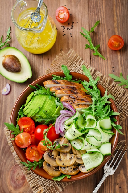 Insalatiera sana con pollo, funghi, pomodori, cetrioli, avocado e rucola