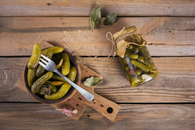 Inscatolamento fatto in casa. Cetrioli marinati cetriolini con aneto e aglio in un barattolo di vetro sul tavolo di legno. Insalate di verdure per l'inverno.