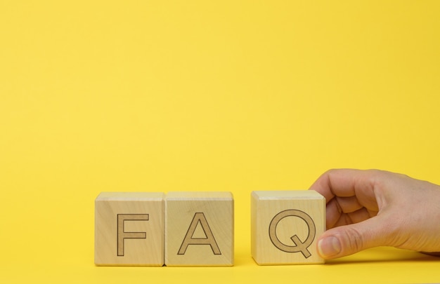 Inscription FAQ (frequently asked questions) on wooden blocks. Q&A concept, help and tips