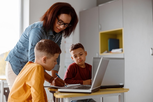 Insegnante afroamericano con gli occhiali e bambini durante la lezione in classe