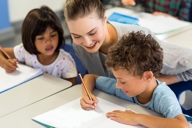 insegnante aiutare gli scolari a scrivere sul libro