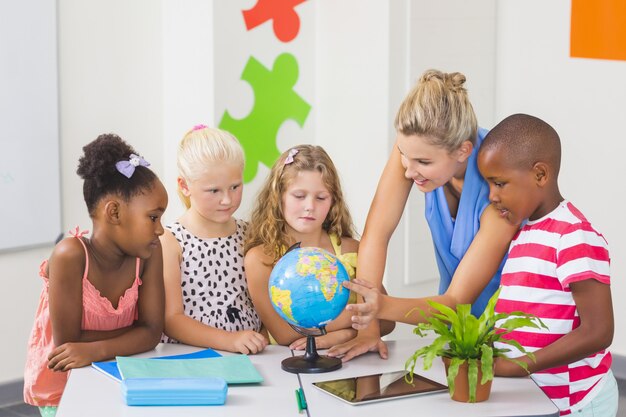 Insegnante che discute globo con i bambini