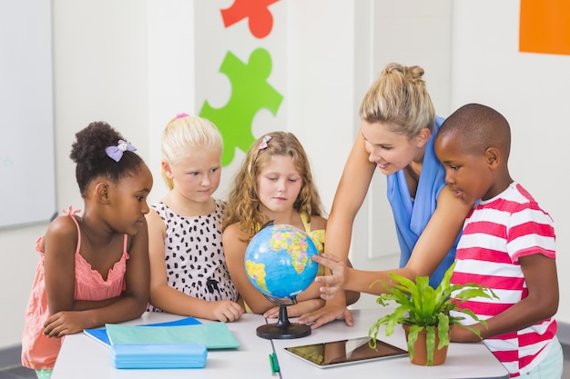 Insegnante che discute globo con i bambini