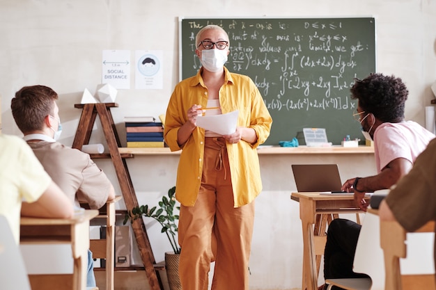 Insegnante che insegna agli studenti a scuola durante la pandemia