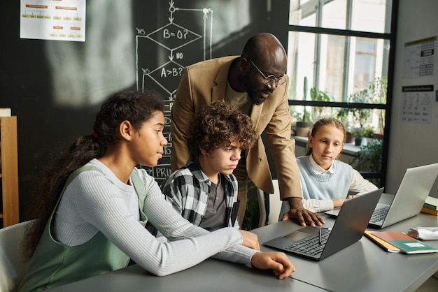 Insegnante che parla ai bambini durante la lezione di informatica