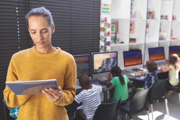 Insegnante che utilizza la tavoletta digitale nella sala computer