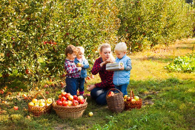 Insegnante con bambini in età prescolare nel giardino delle mele. Interessante lezione di biologia all'aperto