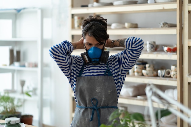 Insegnante di arte della ceramica che indossa il respiratore prima del lavoro