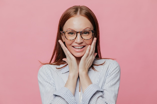 Insegnante di giovane donna attraente con il sorriso a trentadue denti, tocca le guance