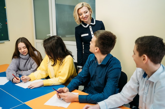 Insegnante di inglese che spiega lezione davanti a studenti adolescenti. concetto educativo.