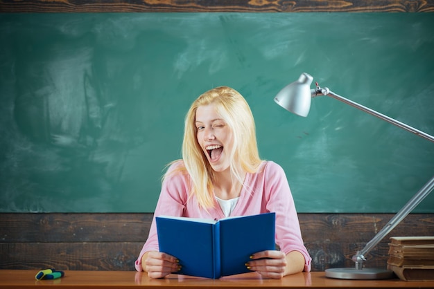 Insegnante divertente e felice che fa l'occhiolino Capo dell'insegnante Studente che studia in classe Insegnante moderno hipster che insegna a scuola