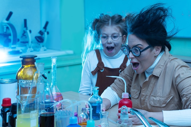 Insegnante e bambina durante la lezione di chimica mescolando prodotti chimici