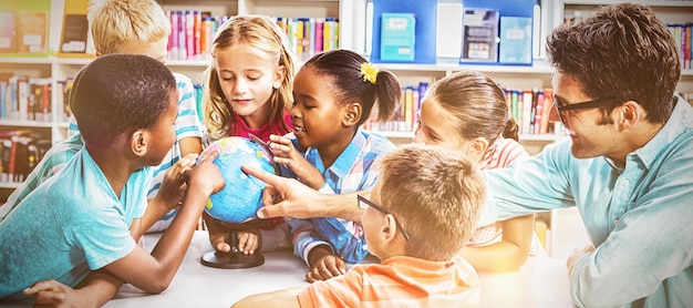 Insegnante e bambini che discutono del globo