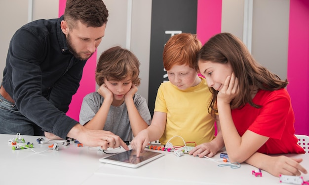 Insegnante e bambini durante la lezione di robotica