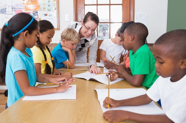 Insegnante ed allievi che lavorano insieme allo scrittorio