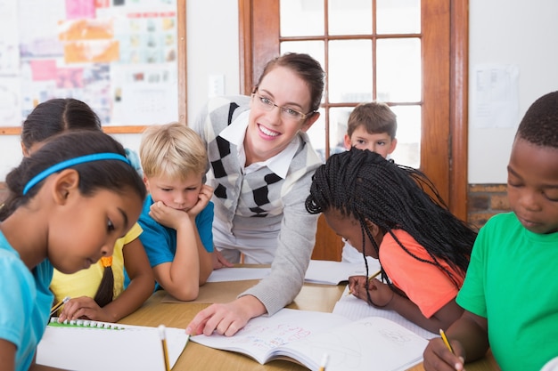 Insegnante ed allievi che lavorano insieme allo scrittorio