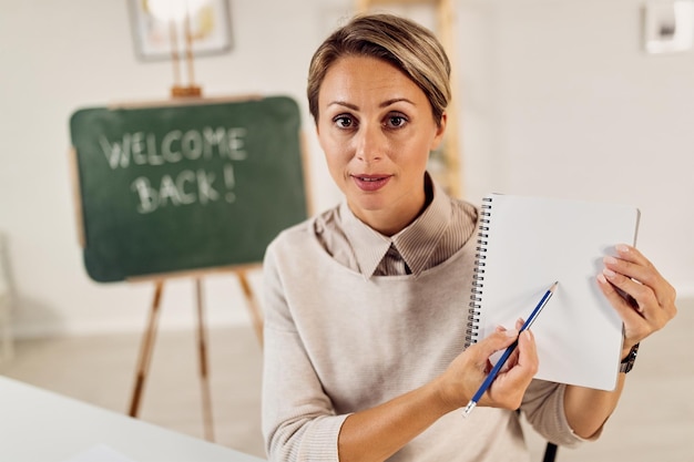 Insegnante femminile che spiega i compiti ai suoi studenti mentre insegna da casa