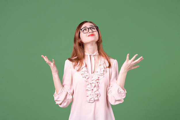 Insegnante femminile di vista frontale in camicetta rosa su sfondo verde lezione universitaria libro di lavoro a colori studente lavoro biblioteca giovane donna