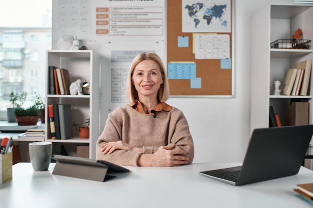 Insegnante seduto al suo posto di lavoro in classe