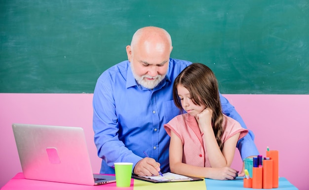 Insegnante senior e ragazza a scuola lezione Metodo di insegnamento moderno Studentessa con insegnante uomo alla lavagna Studentessa e tutor con laptop Conoscenza moderna Istruzione moderna Studente felice