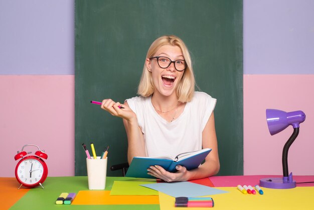 Insegnante Shcool in classe su sfondo lavagna Ritratto professionale Studentessa prendendo appunti da un libro in biblioteca