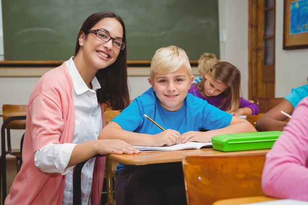 Insegnante sorridente che aiuta uno studente