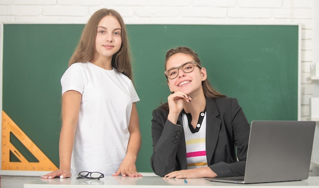 Insegnante sorridente con gli occhiali con lezione di avena con il computer, ritorno a scuola