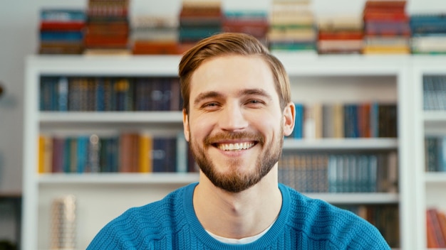 Insegnante sorridente sullo sfondo dei libri