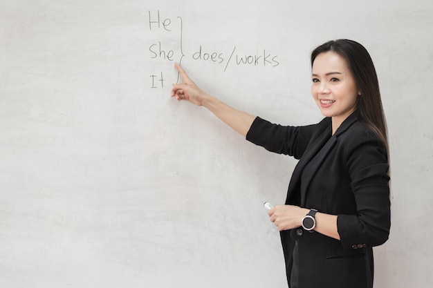 Insegnante universitario femminile asiatico adulto che insegna online tramite videoconferenza agli studenti a casa