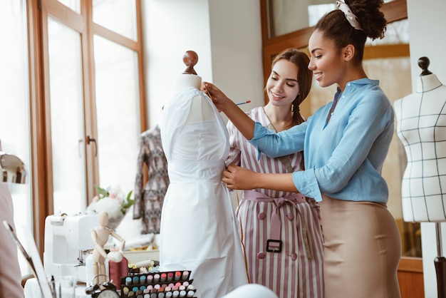 Insegnare a prendere le misure per il nuovo vestito di due donne in studio di design