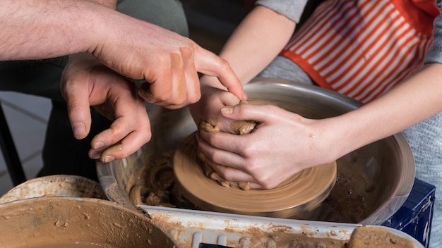 Insegnare la ceramica ai bambini. L'insegnante tiene una master class in modellazione