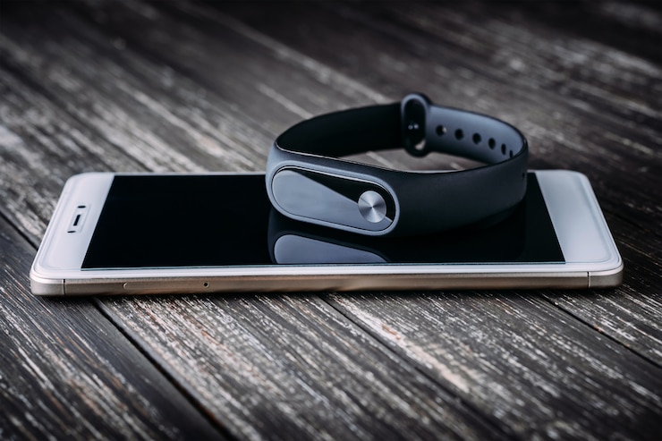 Foto inseguitore nero di forma fisica sullo smartphone bianco sulla tavola di legno