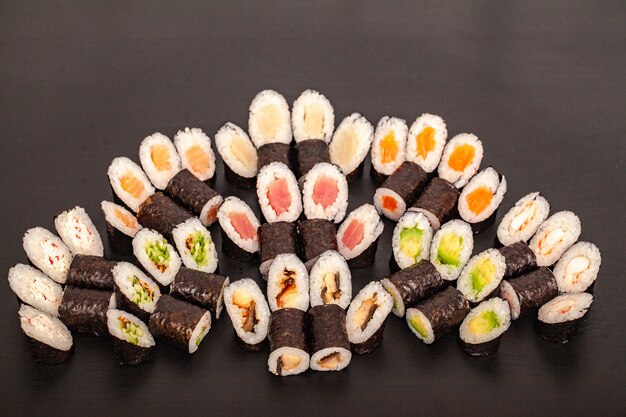 Insieme dell&#39;alimento dei rotoli di sushi sul nero