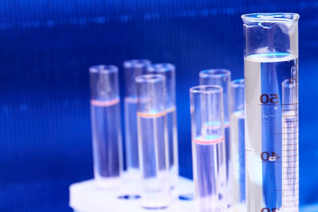 Insieme delle provette di vetro sul concetto blu dell'attrezzatura medica del laboratorio del fondo