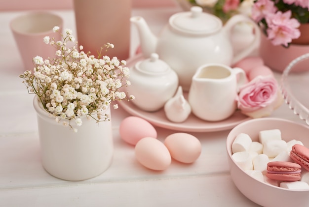 Insieme di tè di Pasqua ed uova variopinte sulla tavola festiva.