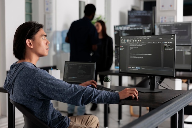 Insinyur aplikasi memprogram algoritma kode server html di komputer, mengetik info data di kantor badan TI. Pemrogram database yang mengerjakan antarmuka pengguna baru dengan sistem online untuk membuat algoritma.