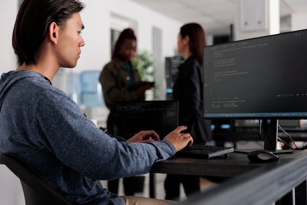 Insinyur memprogram algoritma kode server di komputer, mengetik data sever di kantor agen TI. Pemrogram database mengerjakan antarmuka pengguna baru dengan sistem online untuk membuat algoritma.