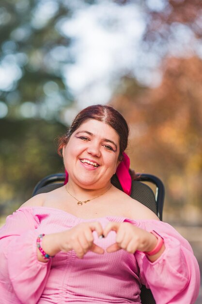 Inspireinclusion forma del cuore amore gesto di San Valentino giovane donna con disabilità di paralisi cerebrale