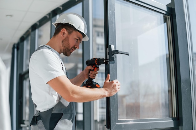 Installazione di nuove finestre Vista ravvicinata del riparatore che sta lavorando all'interno nella stanza moderna