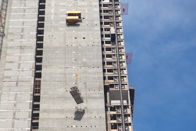 Installazione di una gru a torre in cantiere. L'argano di sollevamento è sollevato.