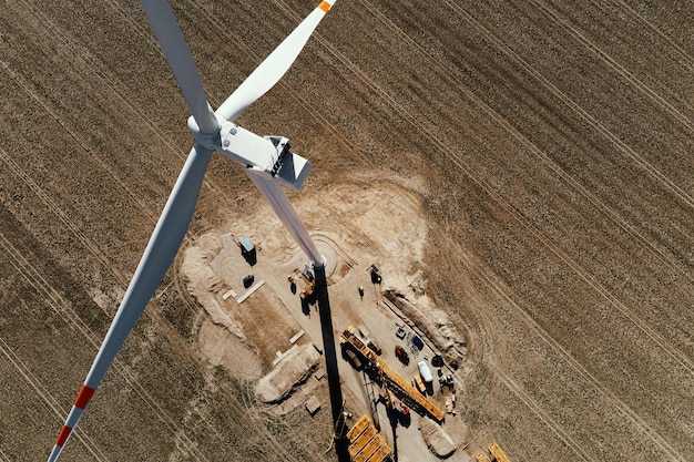 Installazione nuovo generatore eolico Manutenzione turbine eoliche Cantiere con gru per montaggio torre mulino eolico Energia eolica ed energie rinnovabili