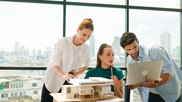 Intelligente discussione di squadra di architetti sulla progettazione della casa mentre un bel lavoratore presenta l'idea usando un portatile Gruppo di ingegneri professionisti che condividono il brainstorming di progettazione Progettazione aziendale Tracery