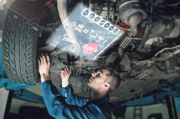 Interfaccia di ingegneria contro il meccanico sotto l'auto in garage