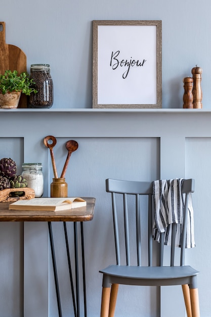 Interior design dello spazio cucina con cornice per foto, tavolo in legno, erbe aromatiche, verdure, frutta, cibo e accessori per la cucina nell'arredamento della casa moderna.