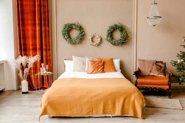 Interior design di Capodanno della bella camera da letto nei toni del beige con l'albero di Natale