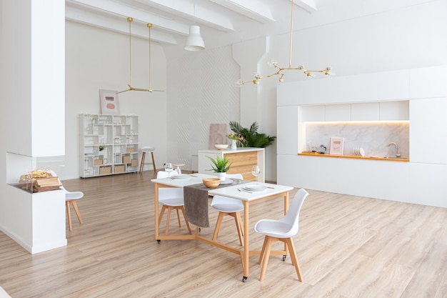 Interior design spazioso appartamento luminoso in stile scandinavo e caldi colori pastello bianco e beige. mobili di tendenza nella zona giorno e dettagli moderni nella zona cucina.