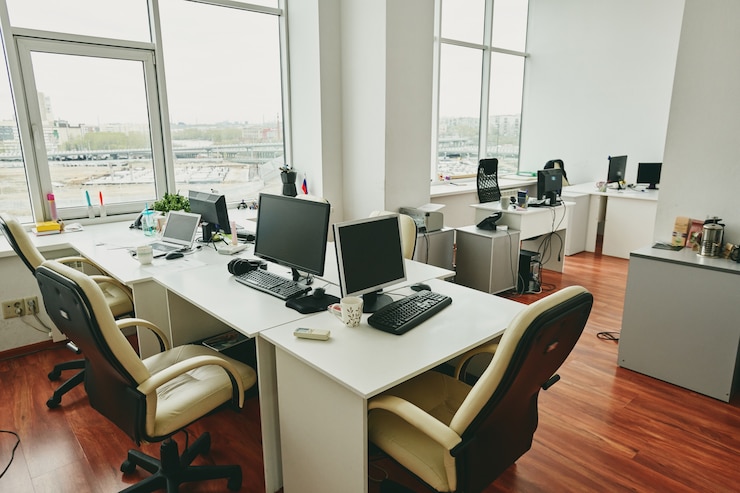 Photo interior of empty modern office with desktop computers on tables placed near each other