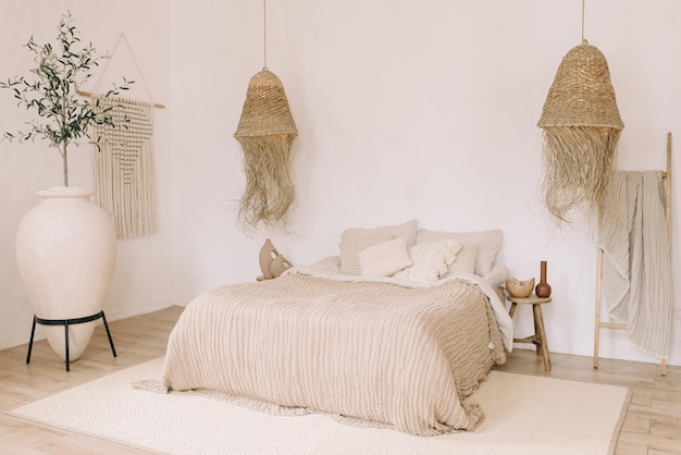 Interiore della camera da letto in stile Boho Tonalità calde e chiare per letto grande lampade decorative in paglia di grandi dimensioni decorative