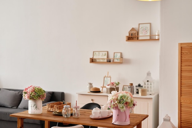 Interni bianchi della cucina in stile loft Scaffali con stoviglie rosa e utensili da cucina Monolocale Affitto e consegna di alloggi Ostello e hotel